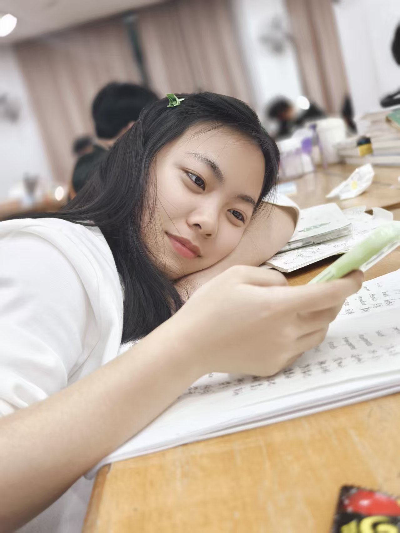 张威趴在课桌上看手机的照片