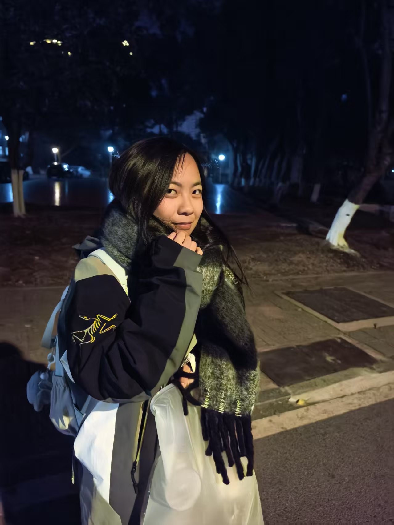 张威围着围巾站在夜路上的照片