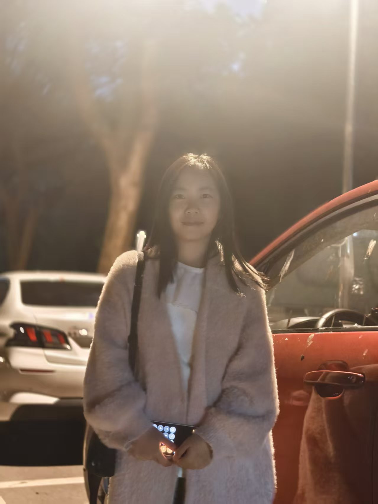 张威站在车边灯下的照片